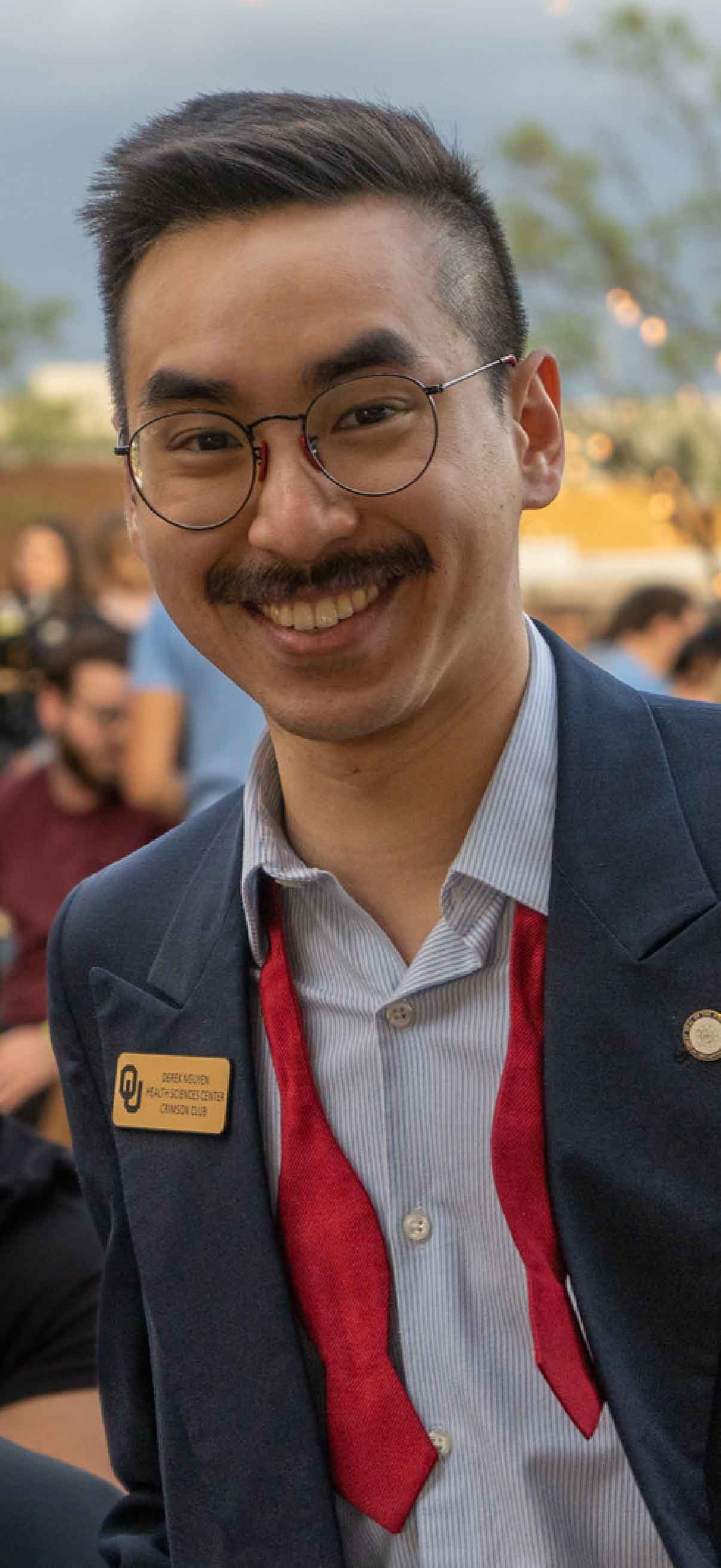 A student in a suit poses during a candid photo at All College Trivia Night.