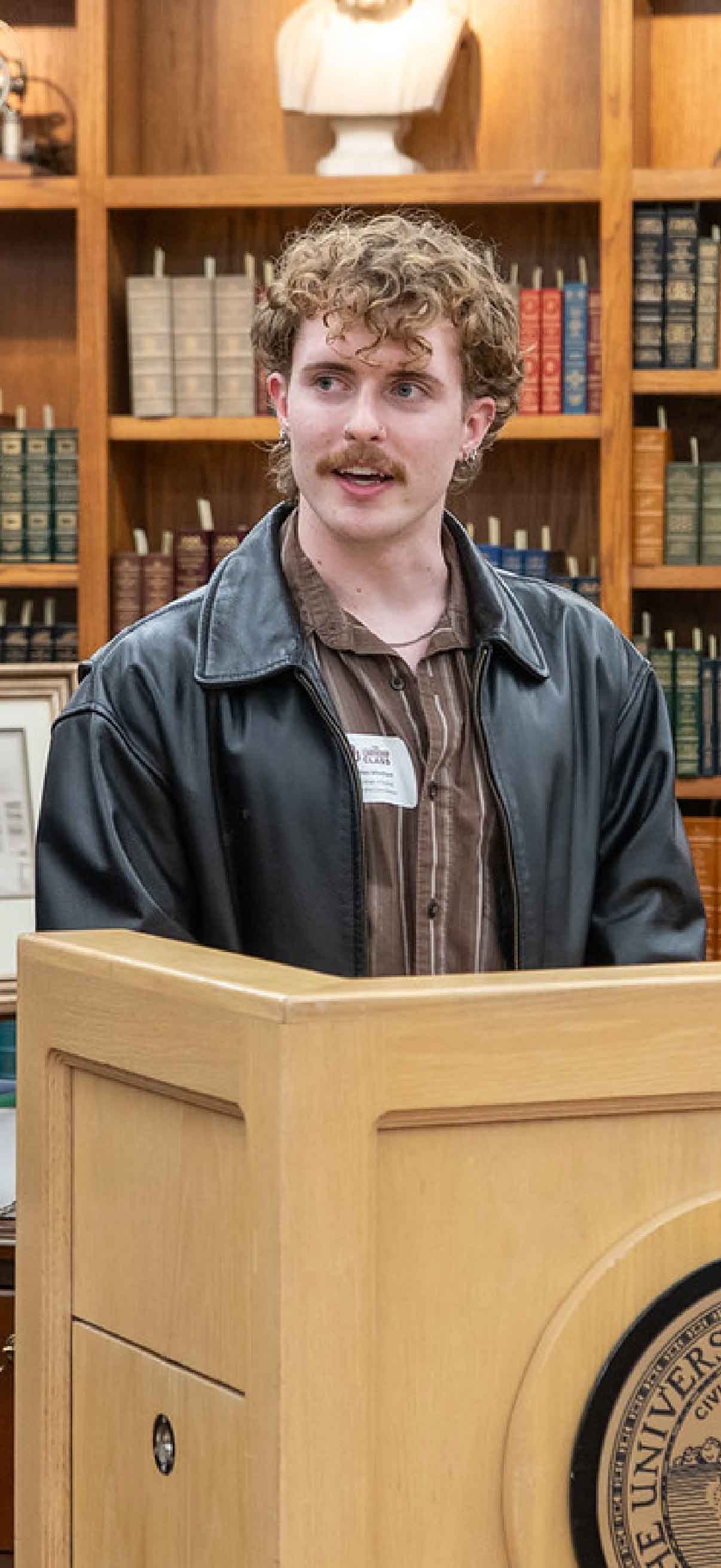 A student advisor for the Leadership Class begins the welcome reception at a podium in the Robert M. Bird Library.