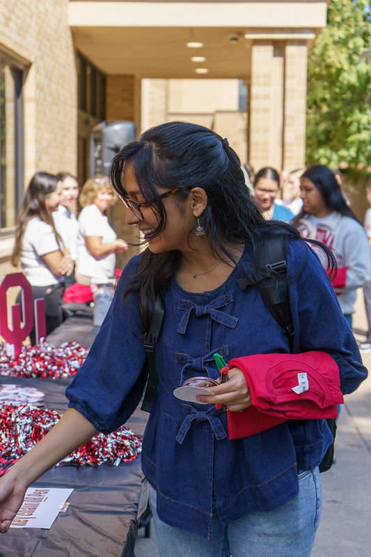 a student picking up a t-shirt and resources from a table outside the Student Union's east entrance
